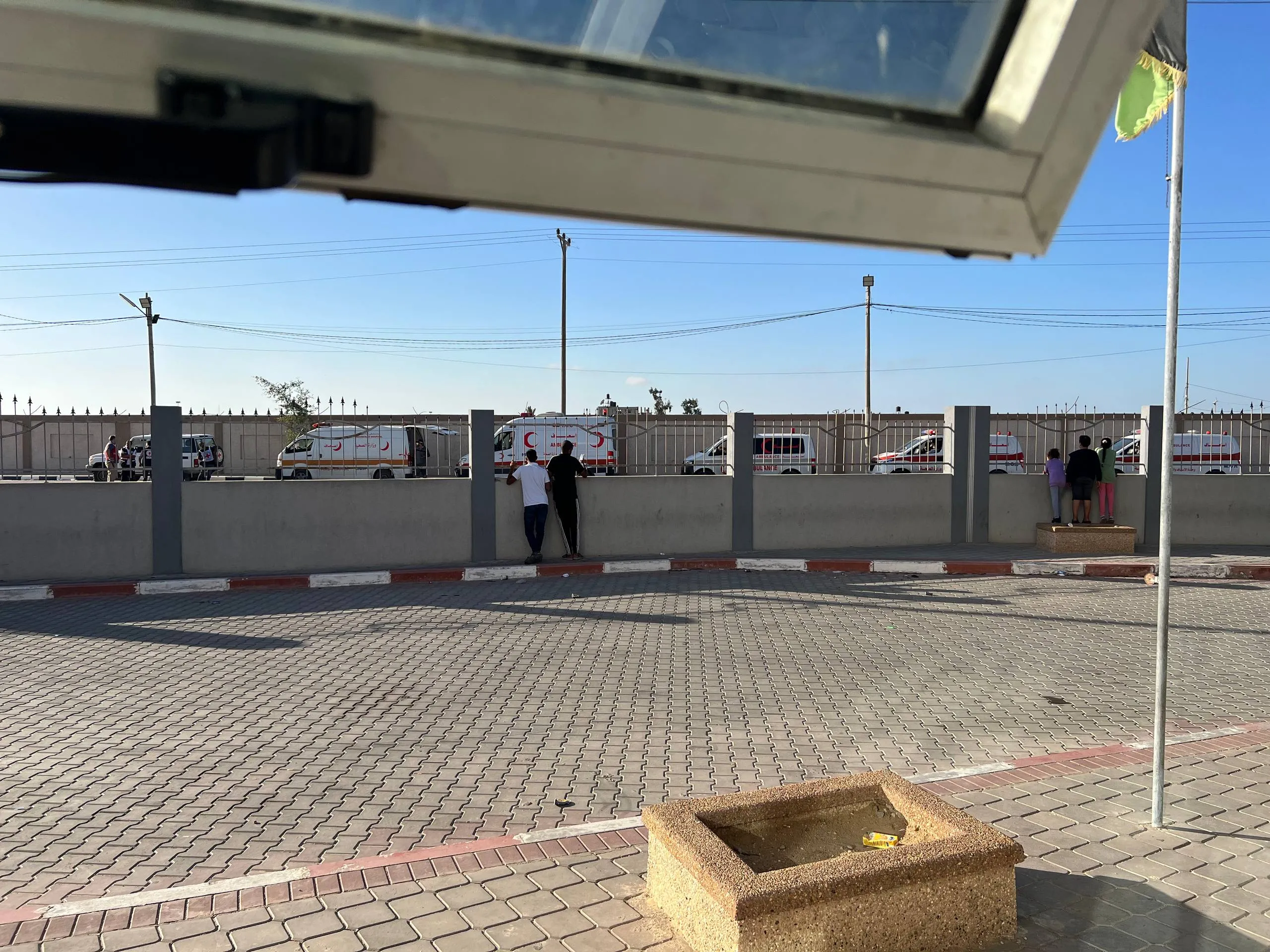 سيارات إسعاف مصطفّة خلف السور